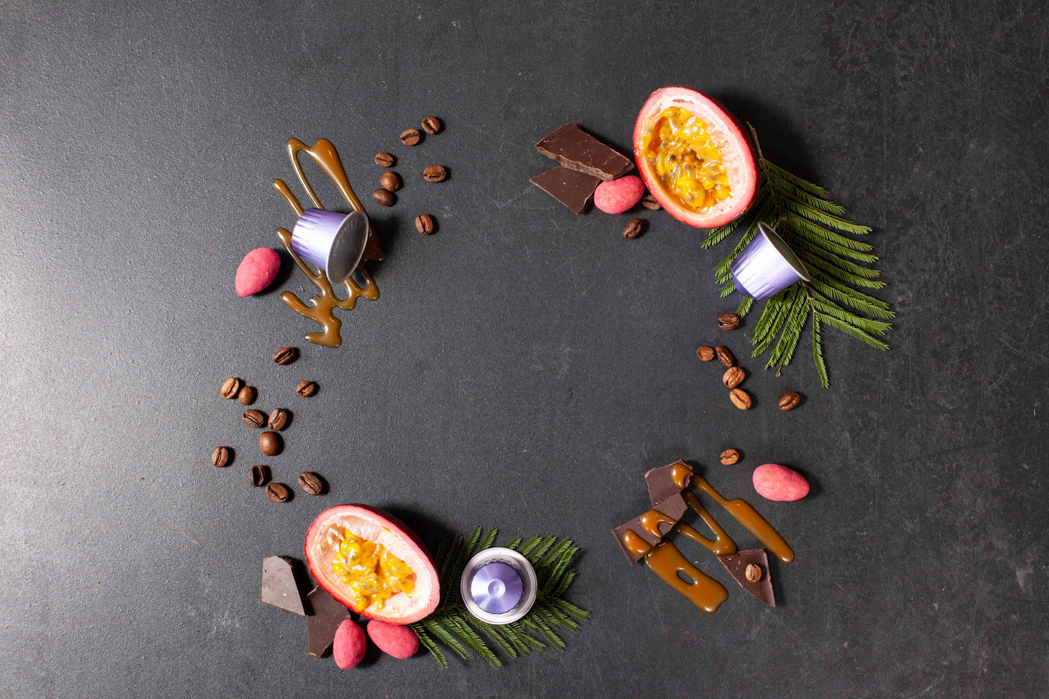 Decorative arrangement of chocolate, passion fruit, and leaves on a dark surface