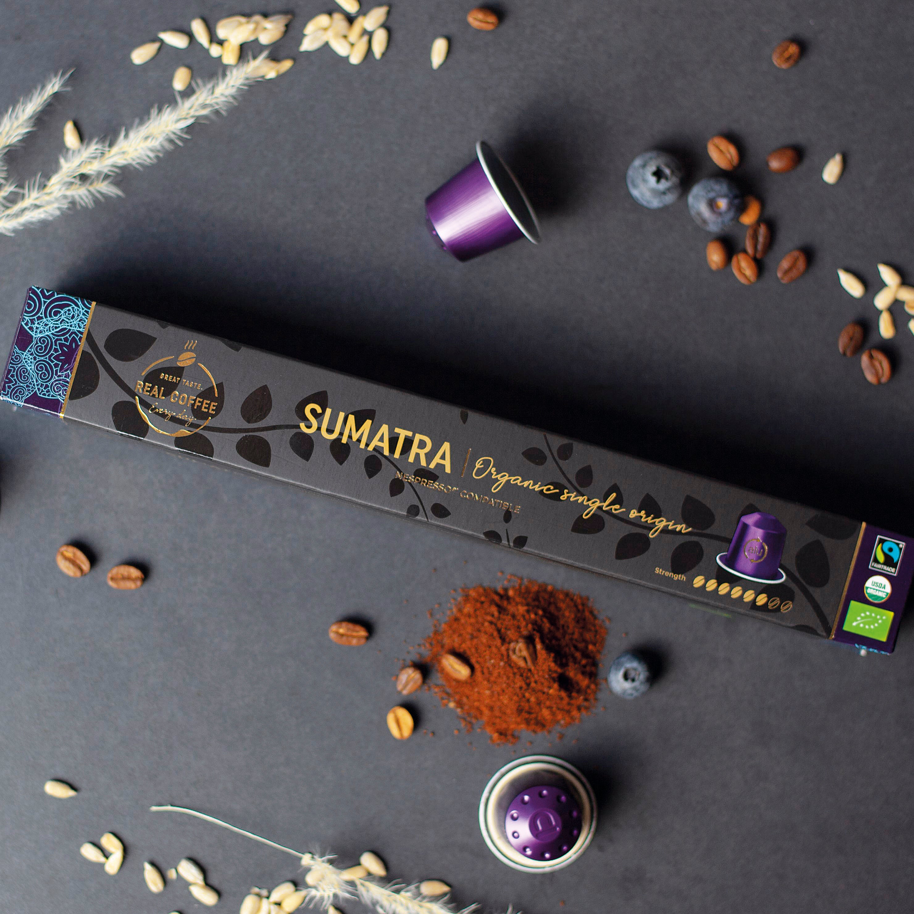 Sumatra organic single origin -Nespresso® compatible coffee capsules -packaging with coffee beans and a purple coffee pod on a dark surface.